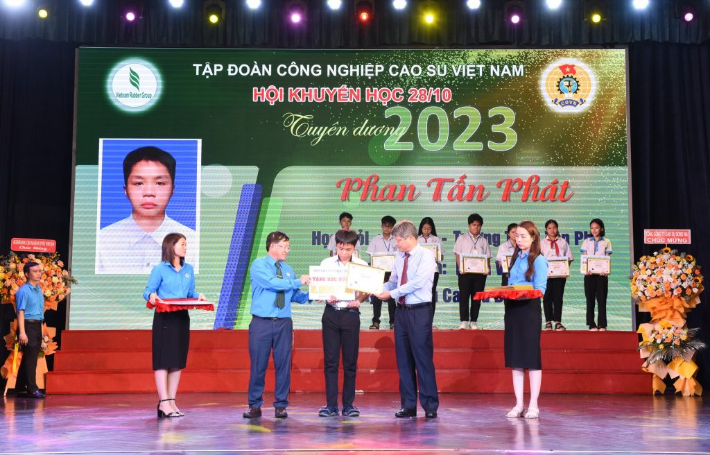 Ông Trần Công Kha – Bí thư Đảng ủy, Chủ tịch HĐQT VRG (bên phải) và ông Huỳnh Kim Nhựt – Phó TGĐ VRG, Chủ tịch Công đoàn CSVN trao thưởng các em HSSV